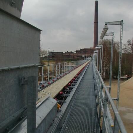Cleated belt conveyor with feeding hopper