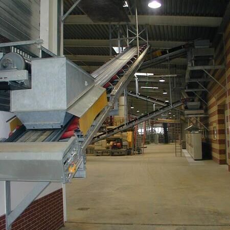 Belt conveyor as a flat runner with tight roller pitch for the transport of complete stone packages